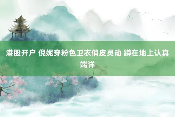 港股开户 倪妮穿粉色卫衣俏皮灵动 蹲在地上认真端详
